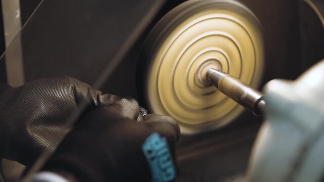 A professional jeweler meticulously polishing a ring, bringing out its shine and brilliance with expert precision and care.