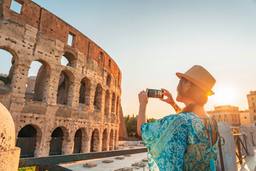 08 08 2025 Rome, Italy - Female tourist taking picture of Colosseum at dusk