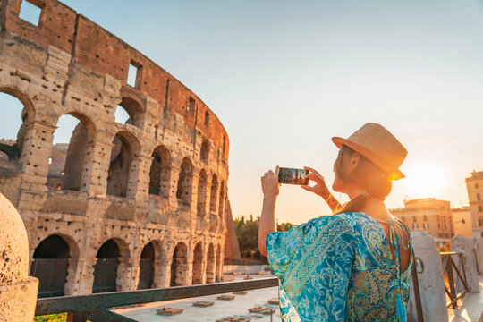 08 08 2025 Rome, Italy - Female tourist taking picture of Colosseum at dusk