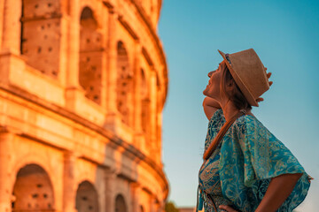 08 08 2025 Rome, Italy - Woman in hat looking up at Colosseum