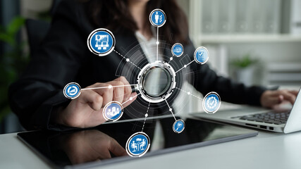 A business professional interacts with technology while analyzing data. Various icons represent different business processes and strategies in a modern workspace. Crux