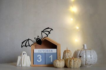 autumn still life. 31 october date calendar, decorative pumpkins, ghost, bat on table close up. cozy festive decor for Halloween, Samhain holidays. idea for fall season interior decoration