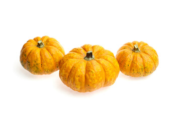 Three vibrant orange pumpkins with textured skin are arranged artistically on a white background, showcasing their unique shapes and colors for seasonal decoration and culinary inspiration