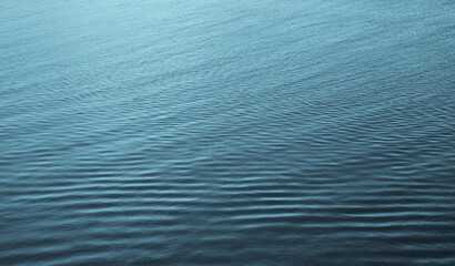 nature light blue backdrop of aqua Water surface with ripple reflections, natural background photo texture with an abstract colorful pattern. Ripples in textured water contrast blue