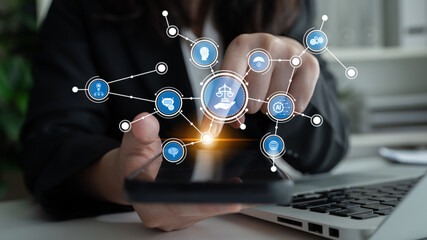 A business professional interacts with a smartphone displaying digital law icons, illustrating the intersection of technology and legal services in a modern workspace. Tessel