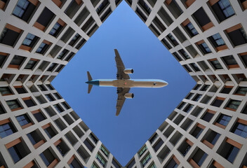 take off landing plane bottom view of passenger commercial  airplane flying above in square rhomb frame made from house, framed by tall home buildings in a geometric courtyard view.