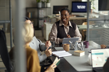 Young Adult Black Woman Leading Business Meeting with Colleagues in Office