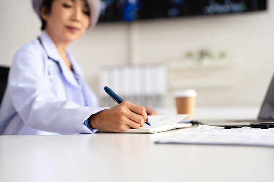 closeup Hand Writing, book and notebook by doctor or healthcare professional with a prescription or making notes in an office.