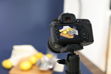 Shooting fresh lemons and juicer with camera in studio, selective focus. Professional food photography