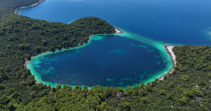 Lagoon by forested coast on Croatian island Mljet, drone parallax