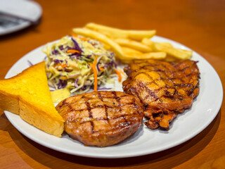Pork steak with potato fried and salad on the table