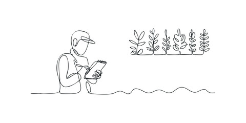 Scientist writing notes near seedling plants