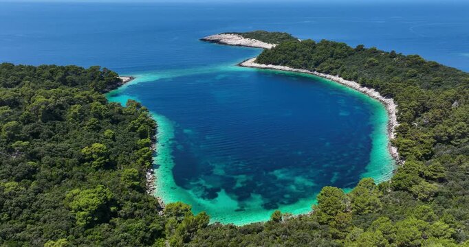 Aerial pan of colorful lagoon and forest at Mljet island in Croatia