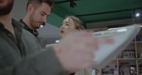 University students collaborate on a project, analyzing data on a tablet and notepad in a library setting. - Powered by Adobe