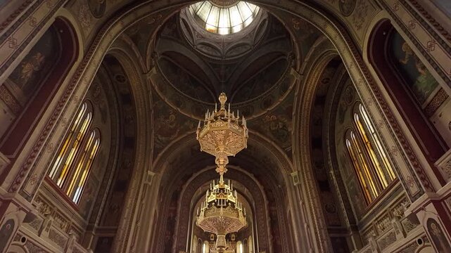 Beautiful interior view of the cathedral in Timisoara, featuring a grand chandelier and intricate architectural details.