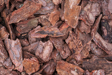 Natural pine bark mulch used for garden decoration and soil protection. Eco-friendly organic material ideal for landscaping and horticulture design projects.