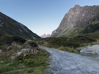 Gravel road winding through a mountain valley landscape