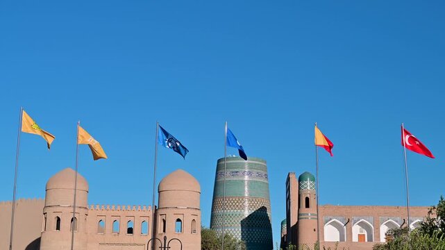 Flags waving in front of Kalta Minor Minaret in Khiva, Uzbekistan
