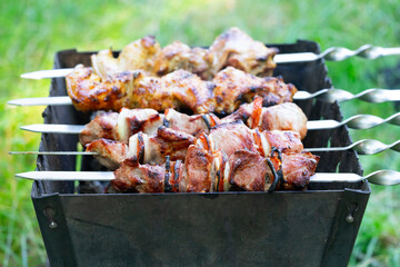 Grilling meat shashlik on skewers outdoors at a summer gathering