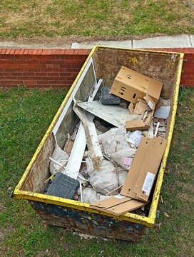  Hire skip bin on the front lawn. The skip bin has some rubbish in it