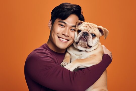 Asian man hugging bulldog pet portrait mammal.