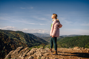 Fototapeta premium Woman enjoying fresh air on mountain peak