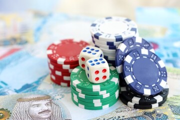 Bahraini dinar currency money bills and casino chips with dices. The concept of gambling and poker casino games