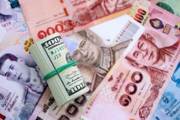 Thai baht currency money bills and bunch of us dollar banknotes close up. The concept of economics and currency exchange