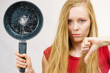 Girl holding scratched frying pan