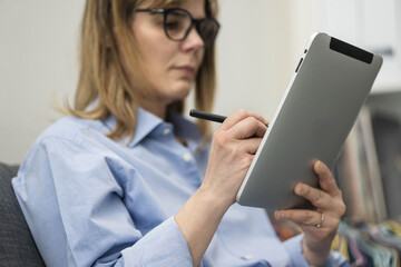 Woman uses stylus on tablet. Girl write with digital pen on device. Modern and efficient workflow