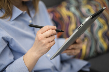 Digital art creation. Close-up of female hands using stylus on tablet. Artist at work, digital pen