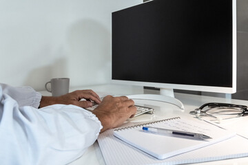 Healthcare professional's hands actively typing on a keyboard, with medical notes and equipment nearby, symbolizing digital efficiency in medicine