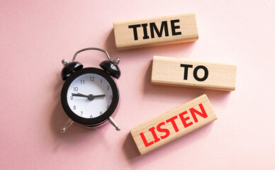 Time to listen symbol. Concept words Time to listen on wooden blocks. Beautiful pink background...