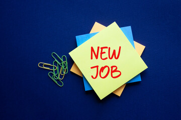 New job symbol. Yellow sticky note with concept words New Job. Beautiful deep blue background....