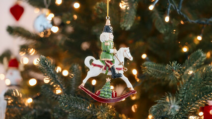 Wooden nutcracker soldier rocking horse ornament Christmas tree glowing with fairy lights...