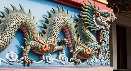 Fototapeta premium Decorative chinese dragon relief on temple wall with blue background