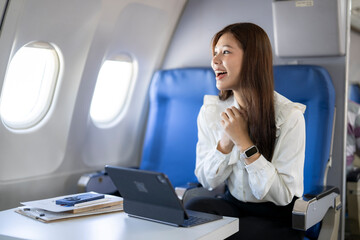 Obraz premium Happy woman traveling by airplane looking out window