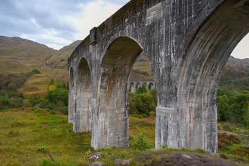Tableau sur plexiglas Viaduc de Glenfinnan Glenfinnan viaduct arches stretching across scottish highlands landscape  © Alejandro
