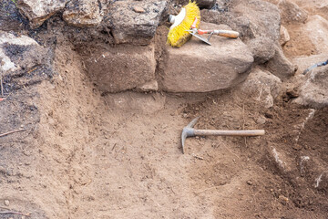 Archaeological tools resting in an excavation trench The Process of Uncovering History
