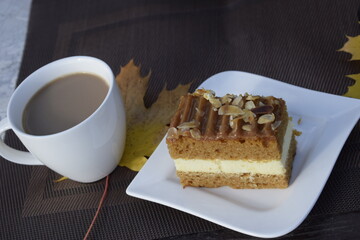Autumn still life with coffee and toffee cake on dark background
