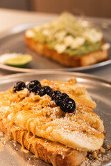 Banana peanut butter toast with blueberries and nuts