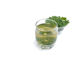 Boiled moringa leaves glass on white background. Healthy drink lifestyle, High angle view	