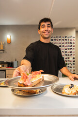 Smiling man serving fresh bruschetta to customers