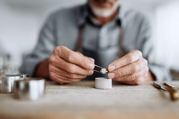 Obraz premium Craftsman delicately handling a diamond ring with tweezers. Symbolizing craftsmanship, precision, and value. Ideal for jewelry, artistry, luxury, and skilled professions.