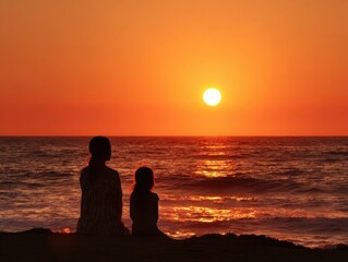Mother daughter silhouettes ocean sunset vibrant orange sky peaceful beach evening family watching sun sink into calm sea horizon tranquil coastal scene summer travel relaxation