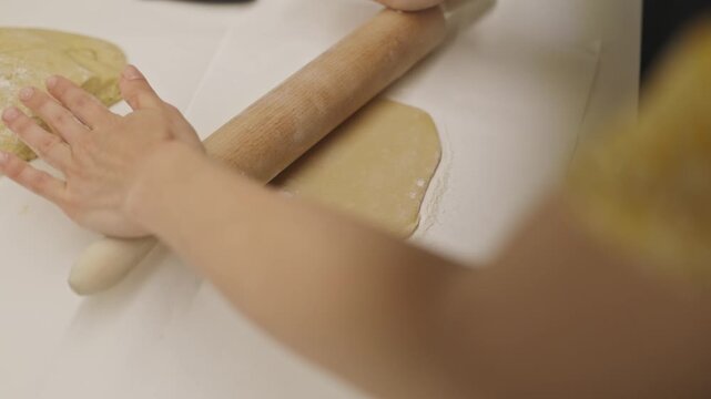 Woman's hands rolling pastry dough with pin