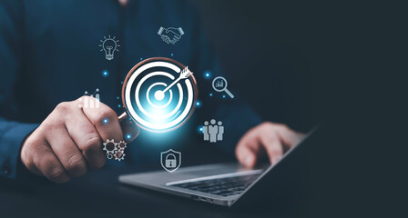 Businessman using laptop with glowing target icon, representing goal achievement, business strategy, marketing success, data analytics, and digital innovation business goal achievement,