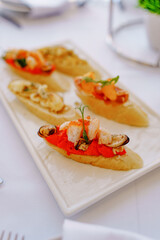 Delicious tapas with seafood served on a white plate