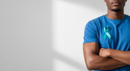 African american man wearing blue shirt with teal ribbon for diabetes awareness on white background. Banner template of medical support and health concept with copy space.