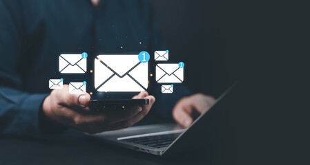 Businessman holding smartphone with floating email icons and notifications, symbolizing digital communication, online messaging, email marketing, data exchange, and modern technology.